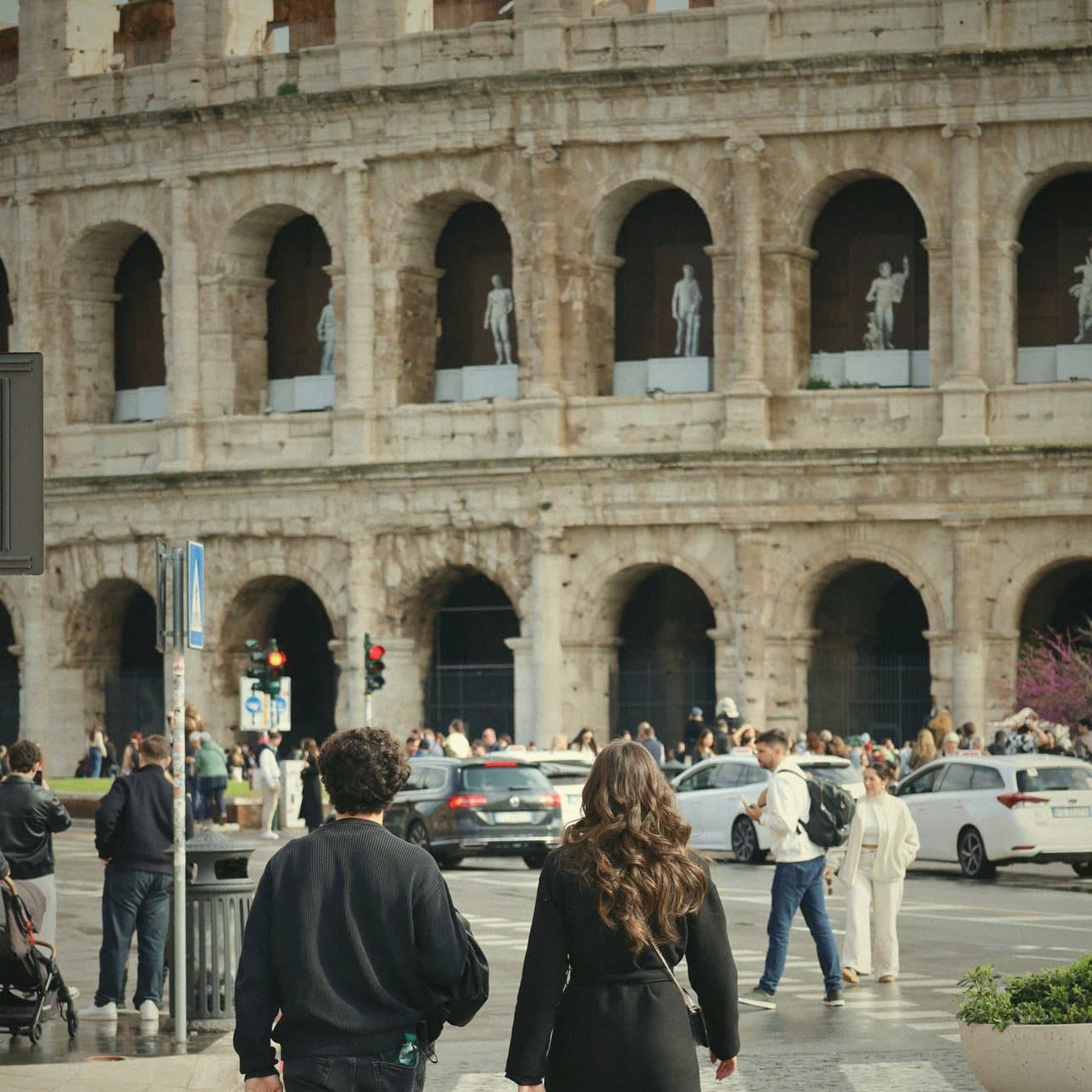 Two friends walking up to the Colosseum, with Trevlo's card pointing to the next stop