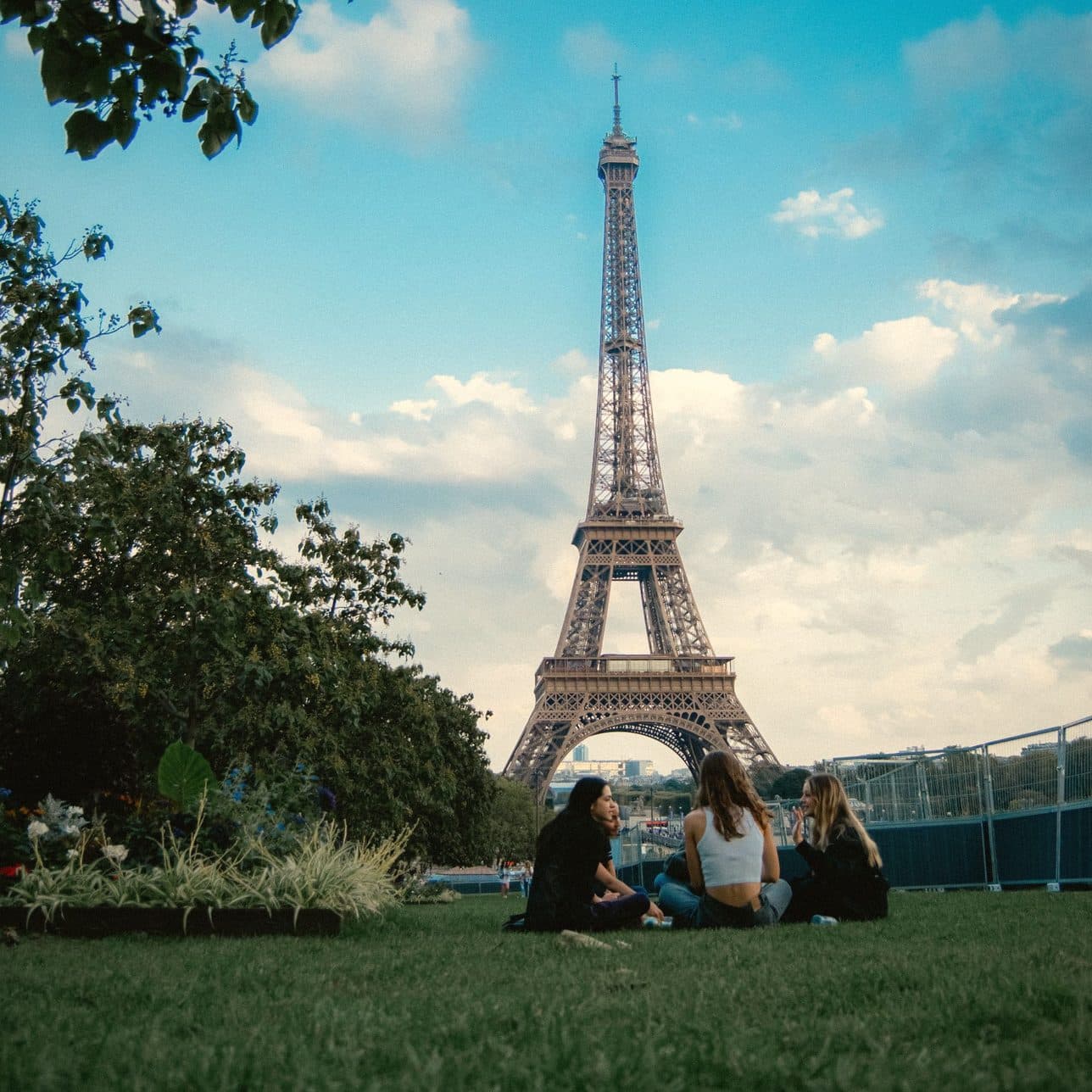 Three friends on the grass in front of the Eiffel Tower
